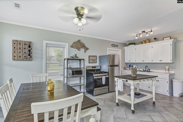 kitchen with crown molding, white cabinets, appliances with stainless steel finishes, ceiling fan, and sink