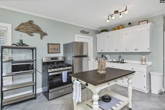 kitchen featuring sink, white cabinetry, light tile patterned floors, and appliances with stainless steel finishes