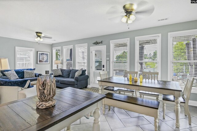 tiled living room featuring ceiling fan and plenty of natural light