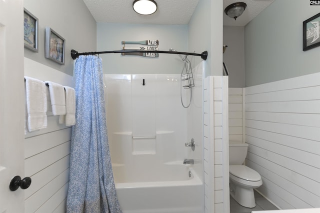 bathroom with a textured ceiling, wooden walls, toilet, and shower / bath combo