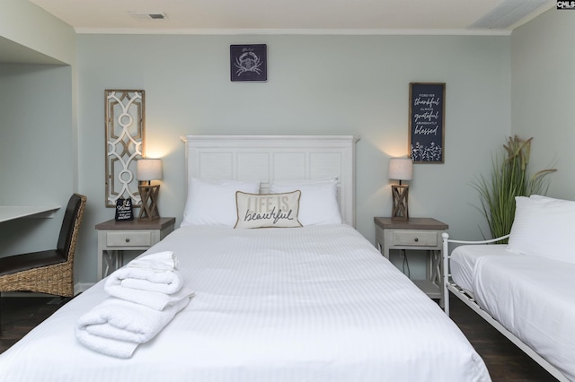 bedroom with dark wood-type flooring and crown molding