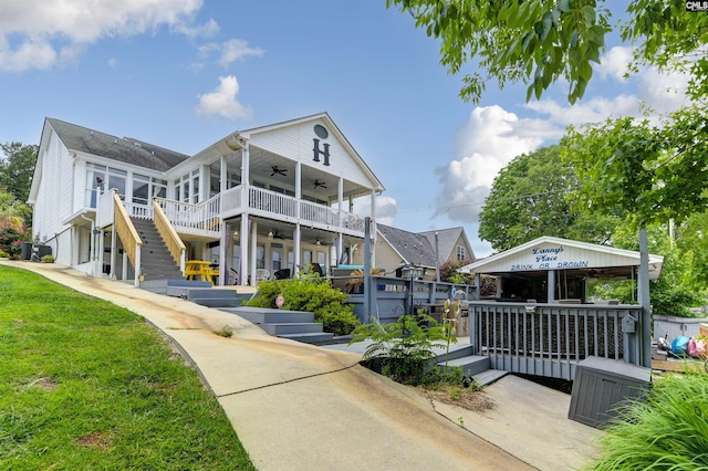 exterior space with ceiling fan, a yard, and a balcony