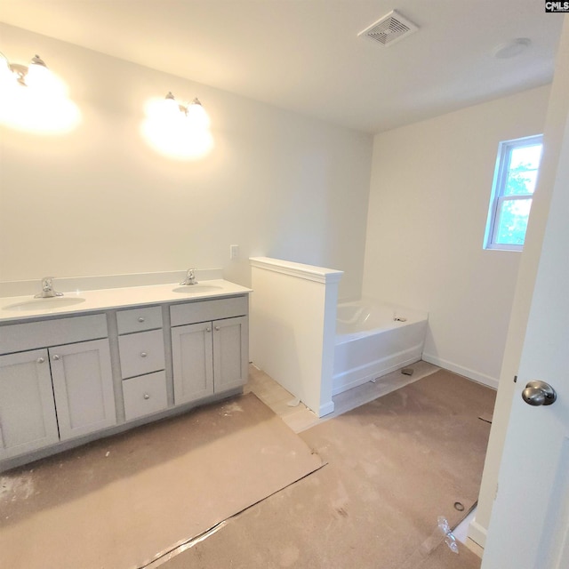 full bath with double vanity, visible vents, a garden tub, and a sink