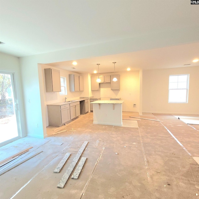 kitchen with gray cabinets, a center island, sink, decorative light fixtures, and stainless steel dishwasher