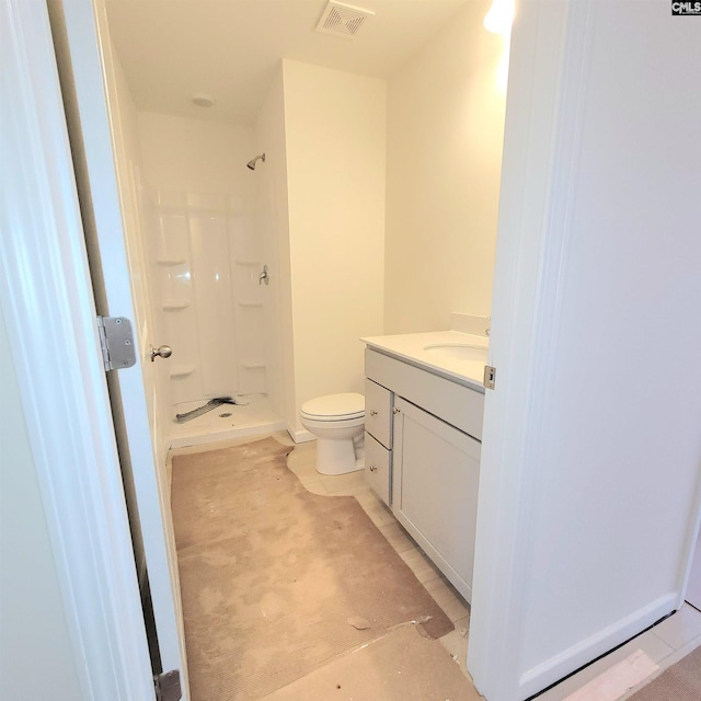 bathroom with toilet, a shower, and vanity