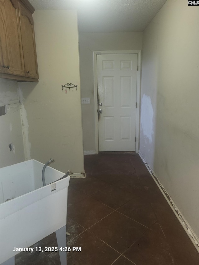 washroom with cabinets and dark tile patterned flooring