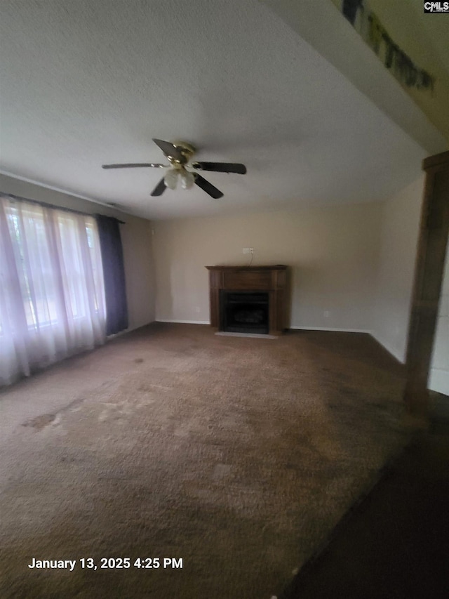 unfurnished living room with ceiling fan, a textured ceiling, and carpet flooring