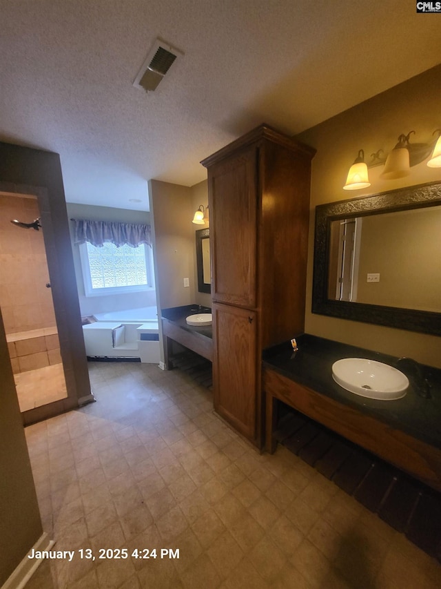 bathroom featuring vanity, shower with separate bathtub, and a textured ceiling