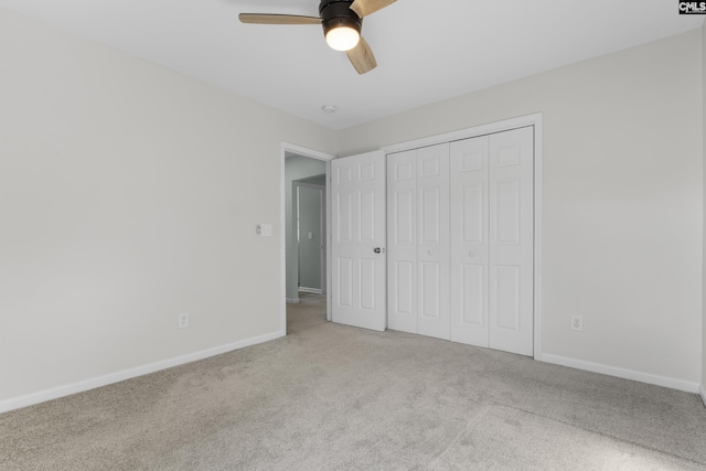 unfurnished bedroom with light colored carpet, ceiling fan, and a closet