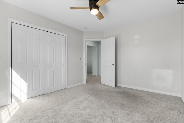 unfurnished bedroom featuring light carpet, a closet, and ceiling fan