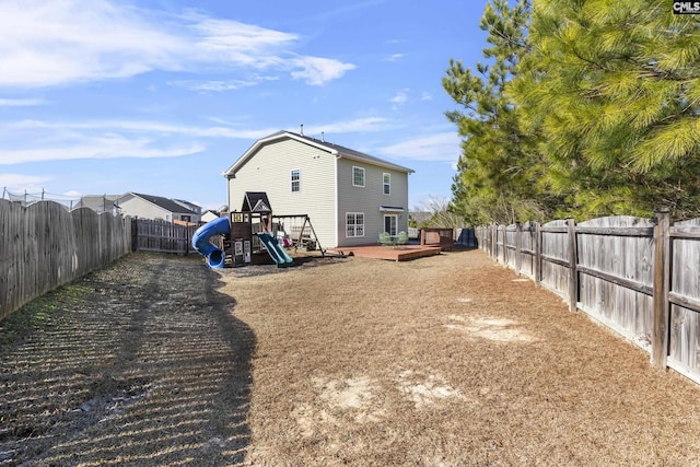 view of yard featuring a wooden deck and a playground