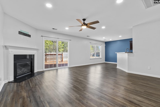 unfurnished living room featuring dark hardwood / wood-style flooring and ceiling fan