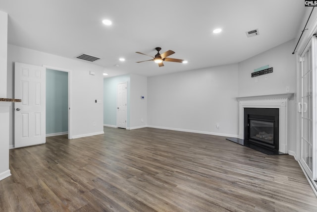 unfurnished living room featuring ceiling fan and dark hardwood / wood-style floors