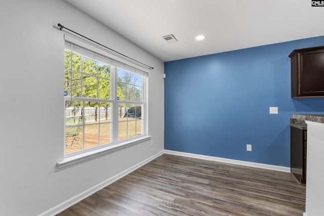 unfurnished dining area featuring dark wood-type flooring