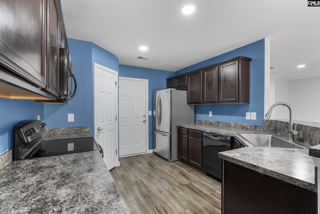 kitchen with stainless steel appliances, dark brown cabinetry, light hardwood / wood-style flooring, and sink