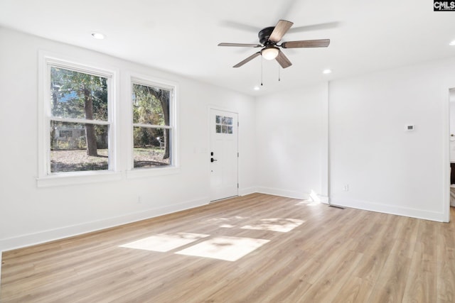 empty room featuring ceiling fan, light hardwood / wood-style floors, and plenty of natural light