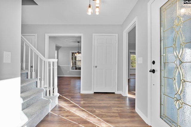 foyer entrance with dark hardwood / wood-style flooring and a chandelier