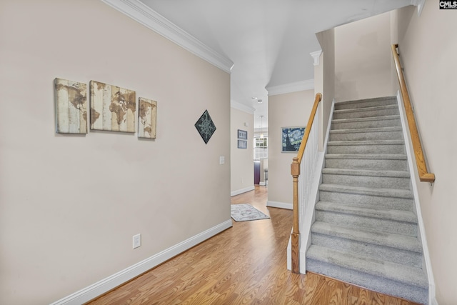 staircase with ornamental molding and hardwood / wood-style flooring