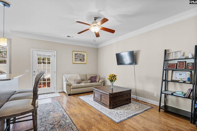 living room featuring ornamental molding, ceiling fan, and light hardwood / wood-style flooring