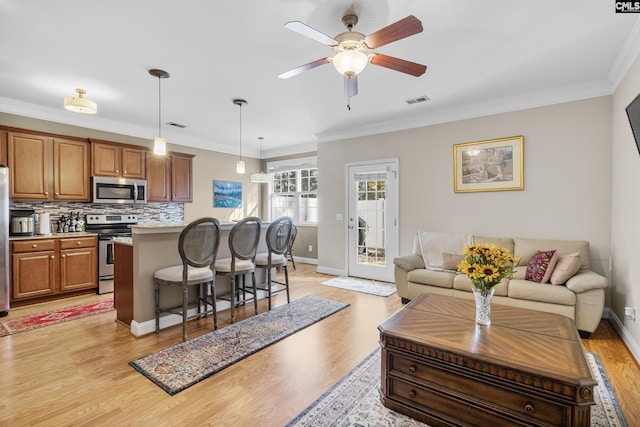 kitchen with hanging light fixtures, stainless steel appliances, a breakfast bar, decorative backsplash, and crown molding