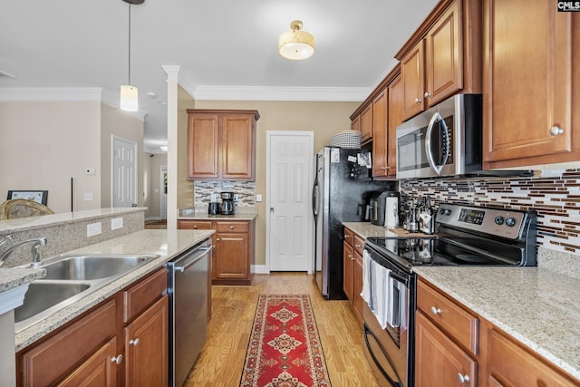 kitchen featuring appliances with stainless steel finishes, light hardwood / wood-style floors, crown molding, light stone countertops, and sink