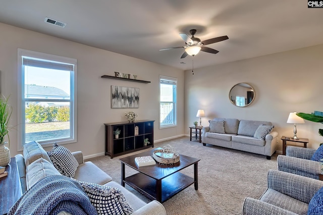 carpeted living room with ceiling fan