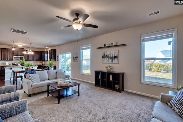 carpeted living room featuring ceiling fan