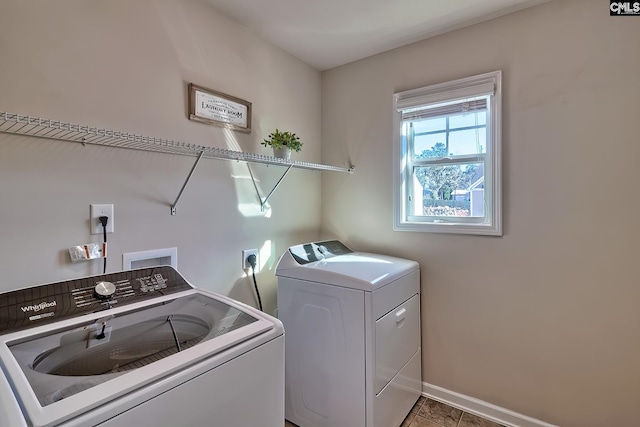 laundry room featuring separate washer and dryer and dark tile patterned flooring