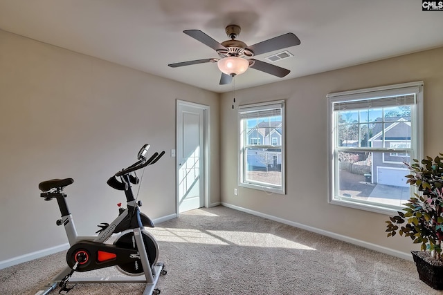 workout area featuring light colored carpet and ceiling fan