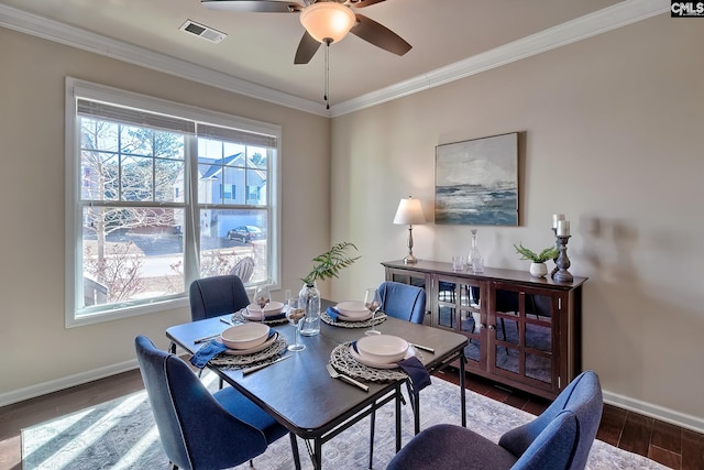 dining room with ornamental molding, ceiling fan, and dark hardwood / wood-style floors