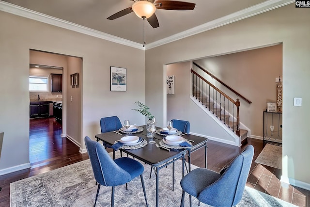 dining area featuring ceiling fan, dark wood-type flooring, crown molding, and sink