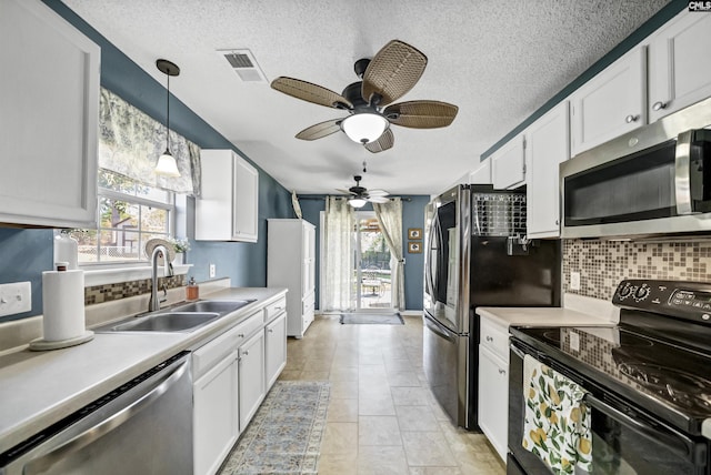 kitchen featuring pendant lighting, stainless steel appliances, backsplash, white cabinets, and sink