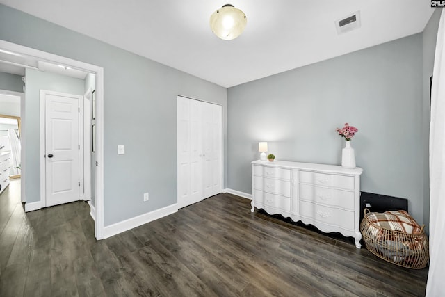 bedroom with a closet and dark hardwood / wood-style floors