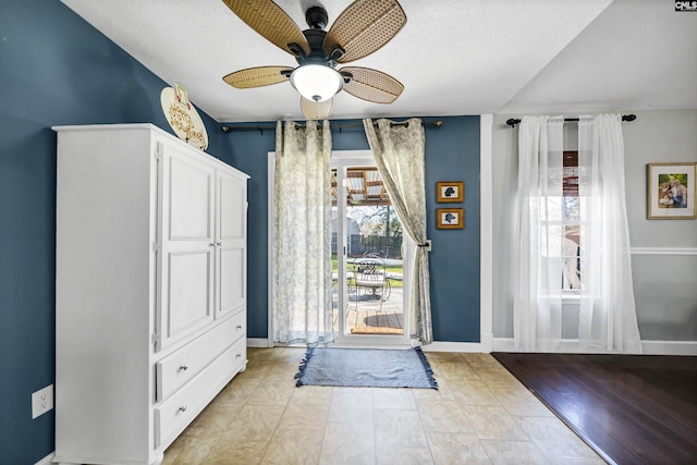 interior space with ceiling fan and a textured ceiling