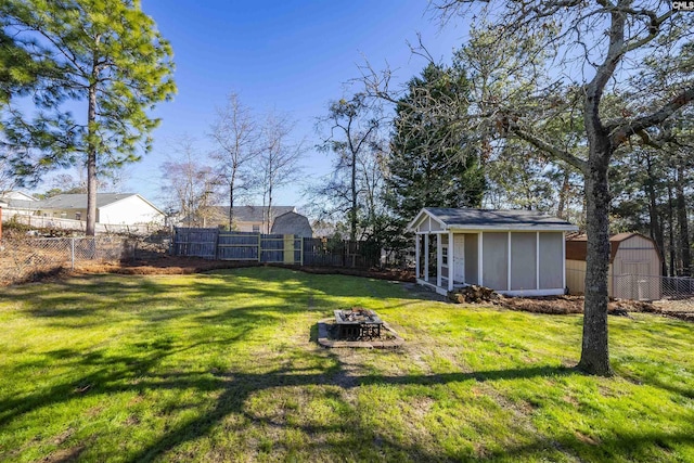 view of yard featuring an outdoor fire pit and a storage shed