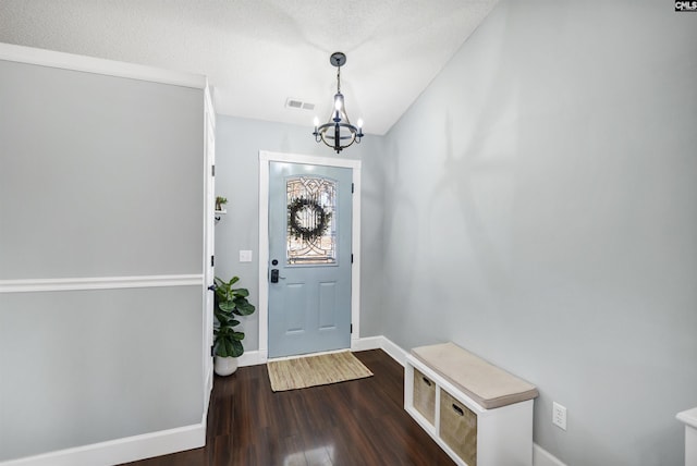 foyer with dark hardwood / wood-style flooring and a chandelier