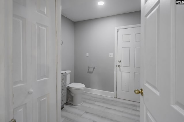 bathroom featuring vanity, hardwood / wood-style flooring, and toilet