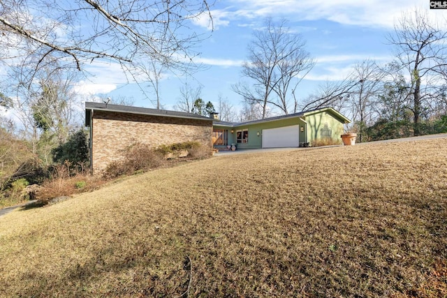 back of house featuring a yard and a garage