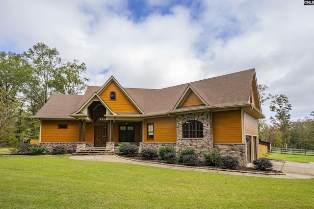 craftsman house featuring a front yard and a garage