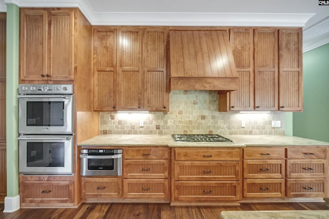 kitchen with stainless steel appliances, ornamental molding, backsplash, and premium range hood