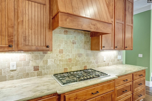 kitchen with stainless steel gas stovetop and tasteful backsplash