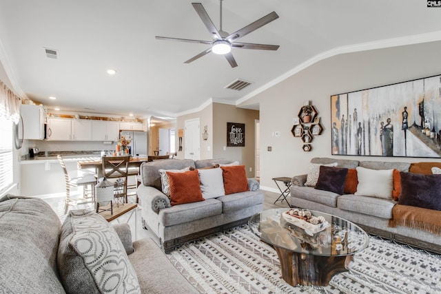 living room with vaulted ceiling, ornamental molding, ceiling fan, and light hardwood / wood-style flooring