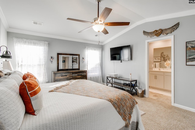 bedroom featuring ensuite bathroom, vaulted ceiling, light carpet, ceiling fan, and crown molding