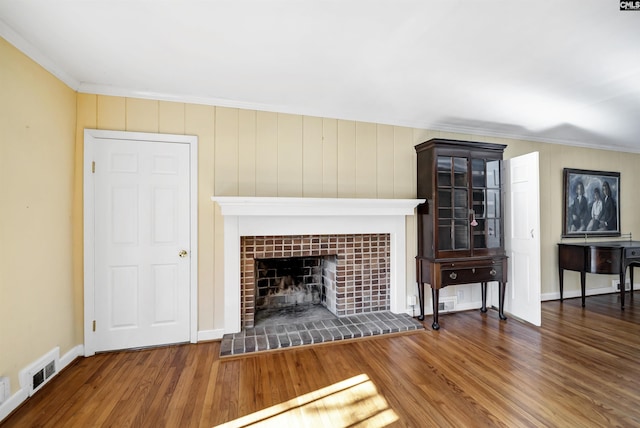 unfurnished living room featuring ornamental molding, dark hardwood / wood-style flooring, and a tile fireplace