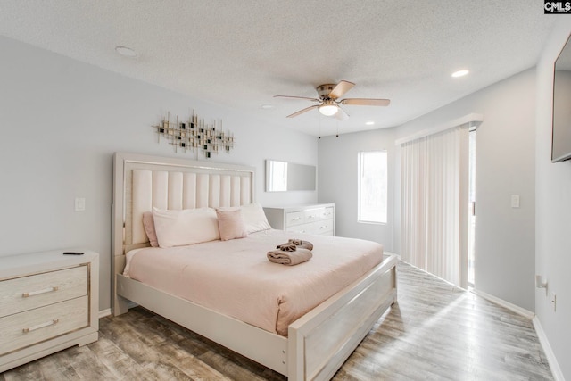 bedroom featuring a textured ceiling, ceiling fan, and hardwood / wood-style floors