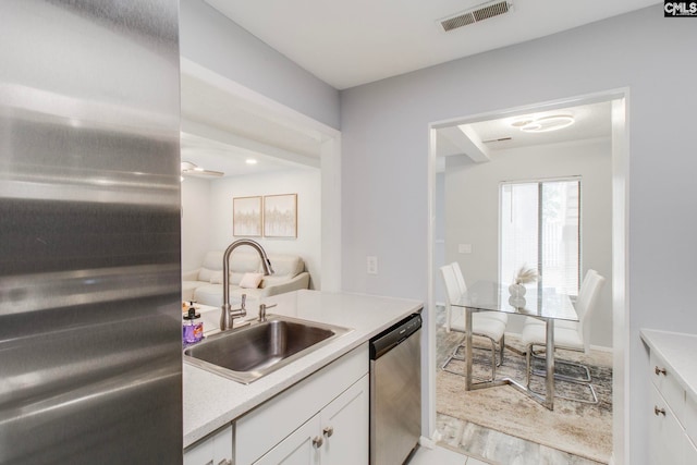 kitchen with appliances with stainless steel finishes, white cabinets, and sink