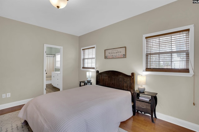 bedroom featuring hardwood / wood-style flooring and connected bathroom