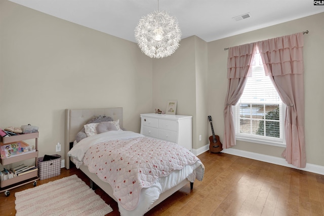 bedroom featuring hardwood / wood-style floors and an inviting chandelier