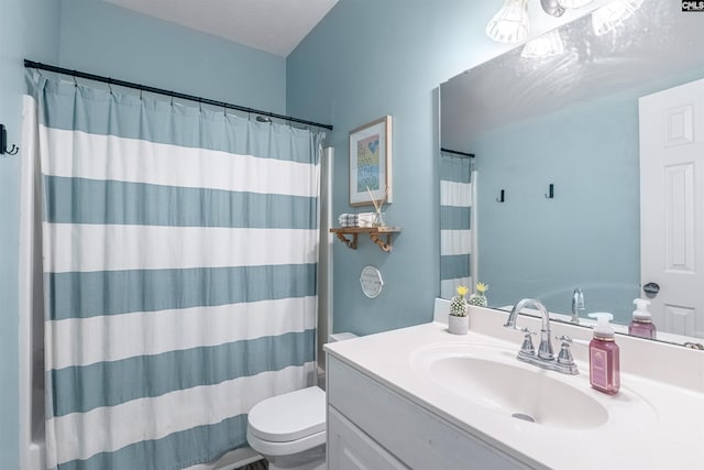 bathroom featuring toilet, vanity, and walk in shower