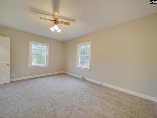 carpeted spare room with ceiling fan and a healthy amount of sunlight